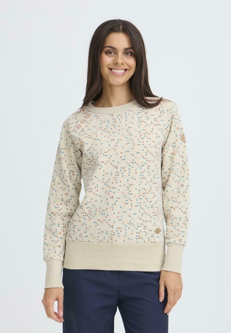 Felpa beige chiaro con motivi a pois colorati, polsini e orlo ribattuti, e bottoni decorativi sulla spalla. Tessuto morbido.