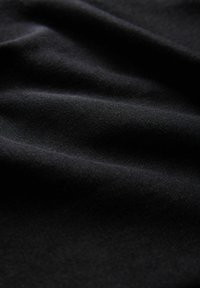 Schwarzer Stoff mit einer glatten Textur, der weiche Falten und einen subtilen Glanz aufweist. Das Material wirkt leicht und vielseitig für verschiedene Anwendungen.