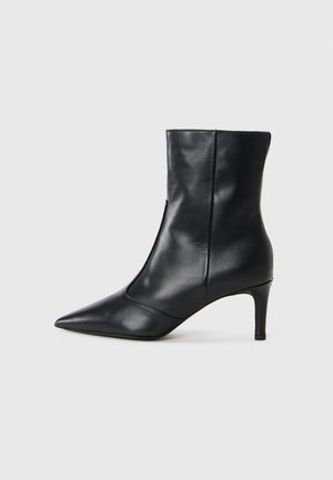 Black leather ankle boot with a pointed toe and a slim high heel, featuring a smooth texture and minimalistic design.