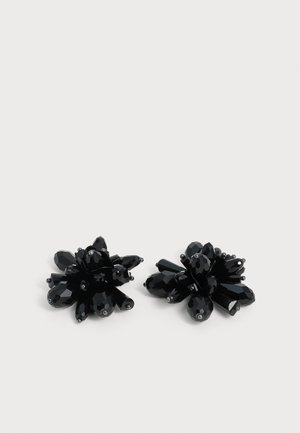 Paire de boucles d'oreilles en grappes de perles noires facettées avec des formes pointues et arrondies sur fond blanc.