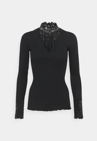 Svart långärmad topp med hög spetskrage och spetssmyckningar vid ärmsluten. Ribbade textur, figursydd design och scalloped nederkant.