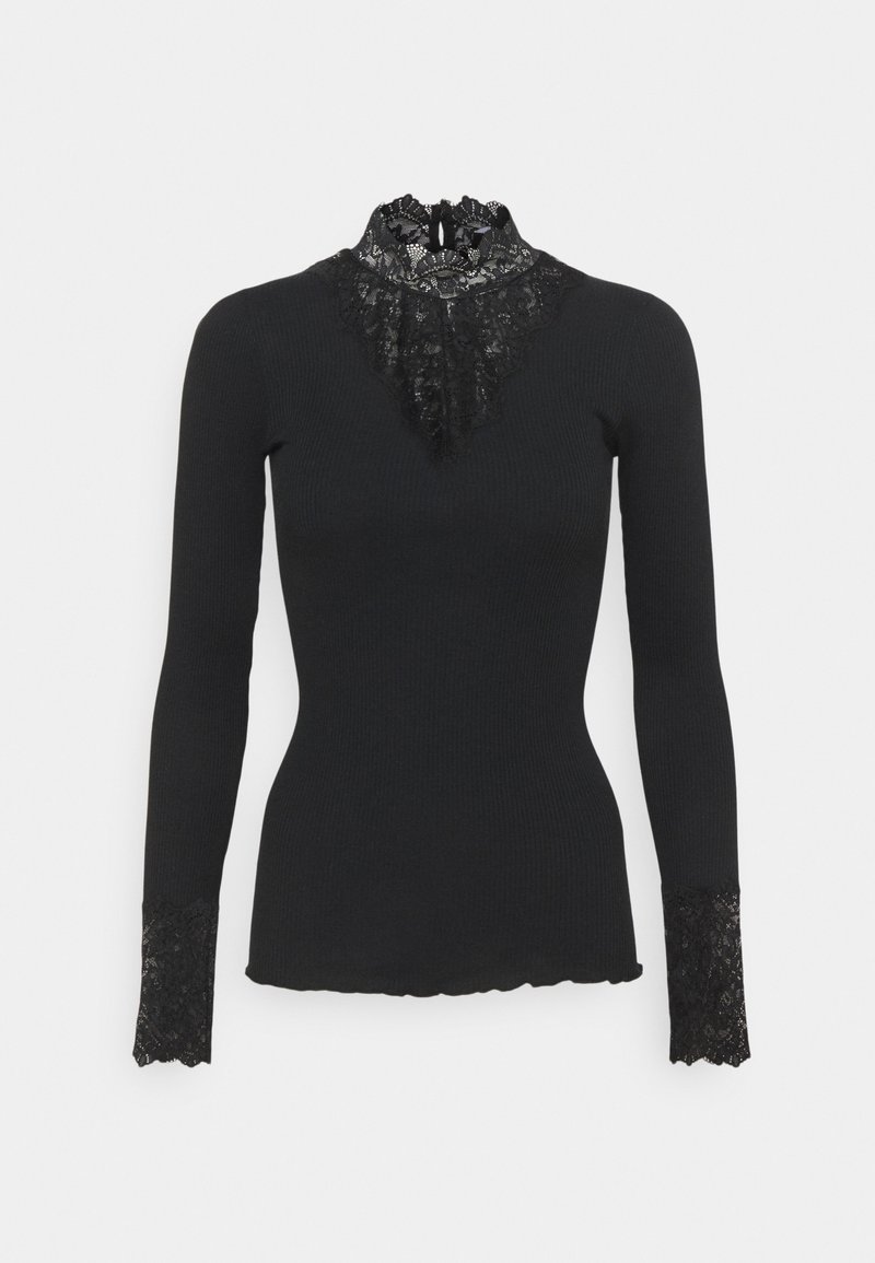Svart långärmad topp med hög spetskrage och spetssmyckningar vid ärmsluten. Ribbade textur, figursydd design och scalloped nederkant.