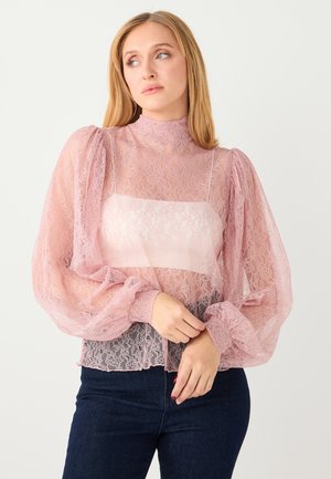 Spitzenbluse in Hellrosa mit hohem Kragen, Puffärmeln und transparentem Stoff. Das Design verfügt über ein festes Einsatz am Oberteil.