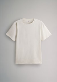 Schlichtes kurzärmeliges Baumwoll-T-Shirt in Off-White mit rundem Ausschnitt, flach auf einem hellgrauen Hintergrund liegend.