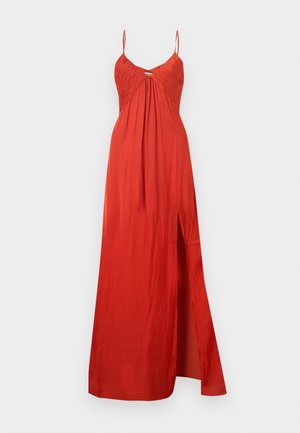 Robe longue rouge avec bretelles fines, poitrine froncée, centre froncé et fente haute sur la cuisse gauche.