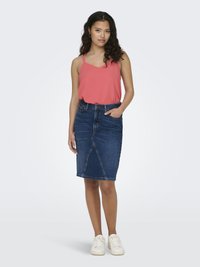 Denim kokerrok met een licht verouderde afwerking, met een aansluitende silhoutte, middelmatige lengte en voorzakken. Gecombineerd met een koraal kleurig tanktop en witte sneakers.