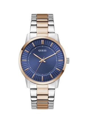 Montre-bracelet pour homme avec cadran texturé bleu, index et aiguilles de couleur or, bracelet métallique bi-tons argent et or, et logo "GUESS" à 12 heures.