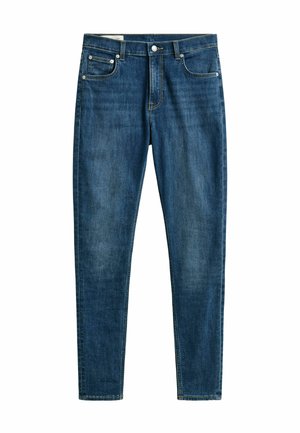 Jean en denim bleu taille fine avec bouton et fermeture éclair à l'avant, conception à cinq poches, et légère décoloration sur les cuisses et les genoux.