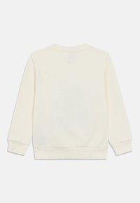 Ανοιχτό μπεζ φούτερ με μακριά μανίκια. Μαλακό ύφασμα, λαιμόκοψη τύπου crew και ριμπ τελειώματα στα μανίκια και στο τελείωμα. Μινιμαλιστικός σχεδιασμός, χωρίς εμφανή λογότυπα.