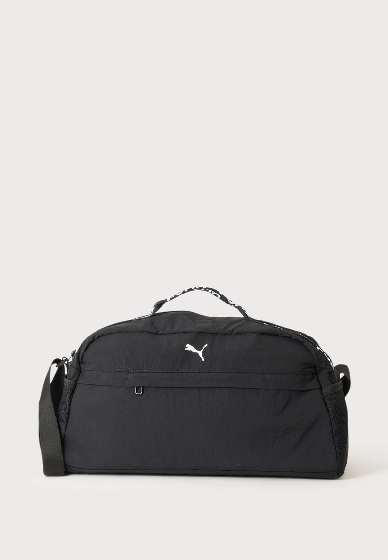 Sac de sport noir Puma avec logo blanc, poignée supérieure, bandoulière réglable et poches latérales en mesh sur fond uni.