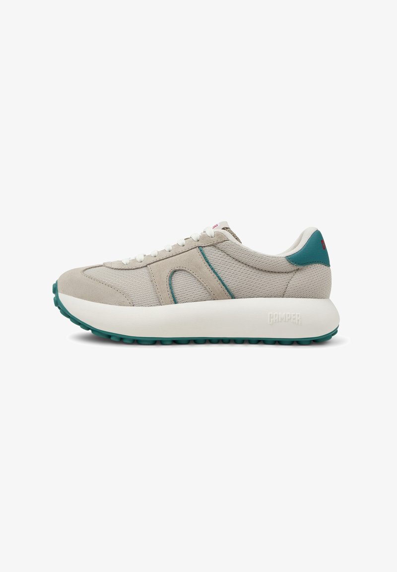 Zapatilla deportiva beige con parte superior de malla, acentos en color teal, cordones blancos, gruesa entresuela blanca y suela exterior de goma texturizada. Logo de la marca en el talón.