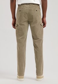 Beige corduroy cargo bukser med afslappet pasform, udstyret med to sidelommer og to baglommer, afsluttet med et simpelt elastisk taljebånd.