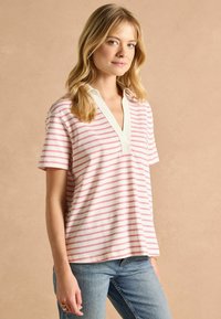 Svītrota kokvilnas polo krekls baltā un gaiši rozā krāsā, ar V veida kakla izgriezumu un īsām piedurknēm, gluda tekstūra, ar ikdienišķu piegulumu.