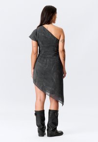 Ασύμμετρο σκούρο γκρι φόρεμα με ένα κοντό μανίκι, υφασμάτινη υφή και διάφανο τελείωμα. Συνδυάζεται με μαύρες μπότες έως το γόνατο.