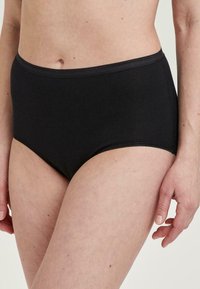 Hochgeschnittene schwarze Baumwollunterhose mit glatter Textur, ausgestattet mit einem weichen elastischen Bund und minimaler Naht entlang der Kanten.