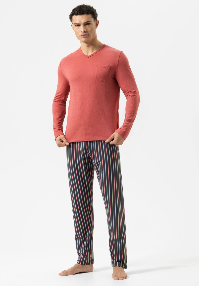 Rotes Langarm-V-Ausschnitt-Oberteil mit einer Brusttasche, kombiniert mit schwarzen gestreiften Hosen, die pinke und blaue Linien aufweisen. Weicher Baumwollstoff, lockere Passform.