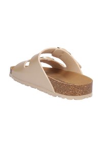 Sandalia beige tipo slip-on con plantilla de corcho, dos tiras anchas con hebillas ajustables y suela de goma texturizada, mostrada desde un ángulo posterior ligeramente inclinado.