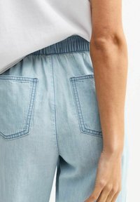 Vaaleansiniset farkut, joissa on joustava vyötärönauha, kahdella takataskulla ja ommelluilla yksityiskohdilla. Pehmeä tuntuma ja rento istuvuus.