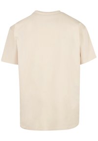 Beige cotton t-shirt, short sleeves, round neckline, plain design, smooth texture, no visible graphics or embellishments, back view.
