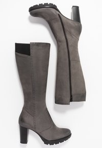 Bottes grises montant jusqu'au genou en cuir lisse avec une fermeture éclair sur le côté, un panneau noir texturé, et un talon épais pour plus de stabilité.