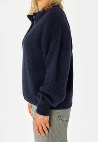 Maglione in lana blu navy con collo alto, chiusura a bottoni e vestibilità comoda. Presenta polsini e orlo a costine, tessuto morbido e testurizzato.