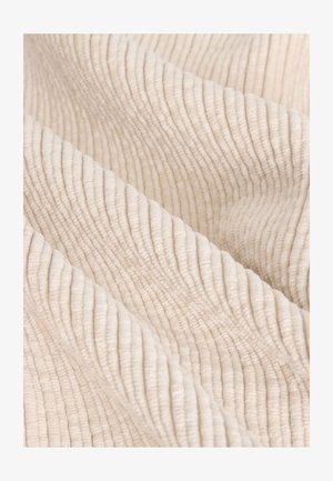 Flødefarvet tekstureret stof med lodrette ribbede mønstre, blød og luksuriøs finish, der fremhæver naturlige fibre.