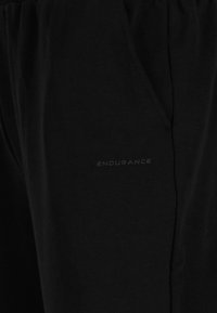 Schwarze Baumwoll-Jogginghosen mit elastischem Bund, ausgestattet mit Seitentaschen und einem dezenten „ENDURANCE“-Logo in matter Ausführung.