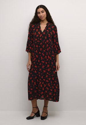 Black, floral-printed midi dress with red flowers, V-neck, three-quarter sleeves, and a tiered ruffle hem, paired with black heels.