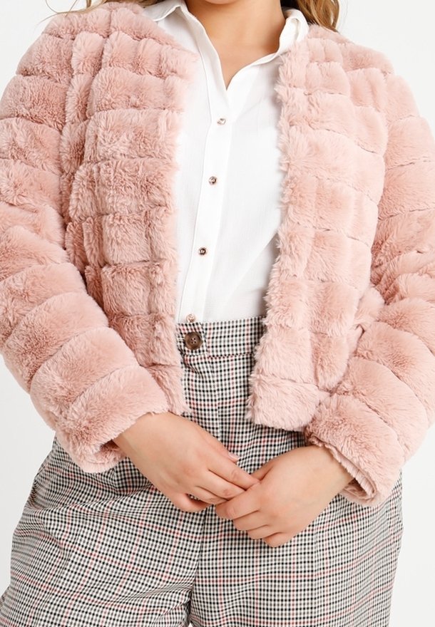Giacca in pelliccia sintetica rosa chiaro con design trapuntato, maniche lunghe e taglio corto, abbinata a una camicia bianca e pantaloni a scacchi.