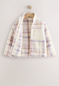 Fleecejakke med lilla og pink ternet mønster, frontlynlås, ståkrave og to forlommer, hængende på en træbøjle.