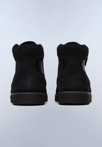 Botas de tobillo de ante negro con un acabado texturizado, que presentan paneles de malla, puntera redonda y una suela de goma plana. La vista trasera muestra una línea suave.