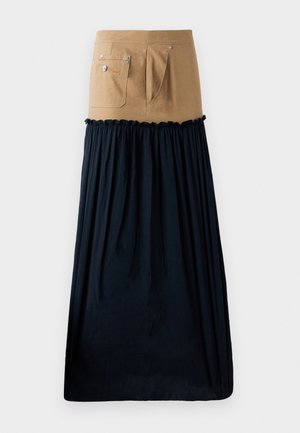 Nadrág hosszú, sötétkék crepe fodros részletekkel; zsebekkel és ezüst színű fémalkatrészekkel rendelkezik; a merev felsőt egy laza alsó résszel kombinálja.