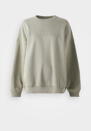 Felpa verde oliva realizzata in tessuto morbido, con collo rotondo, spalle scese e logo adidas in bianco in rilievo sul davanti.