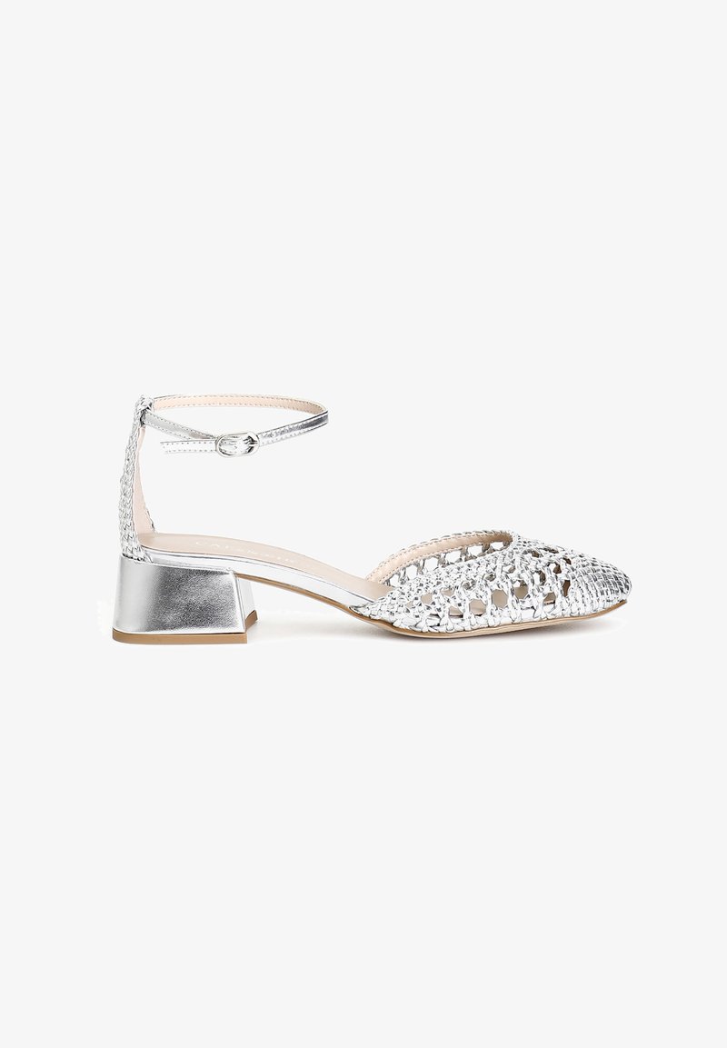 Scarpa con cinturino alla caviglia in argento con tacco a blocco. Presenta una punta aperta e una texture intrecciata sulla parte anteriore. Finitura metallica liscia.