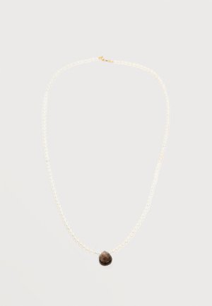 Enojna ogrlica iz perl z obeskom v obliki temno rjavega kapljastega dragulja na zlati zaponki, postavljena na enostavno belo ozadje.