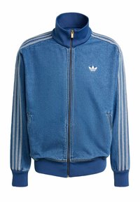 Blaues Denim-Jacke mit Reißverschluss, versehen mit weißen drei Streifen Akzenten an den Ärmeln, hohem Kragen und frontalen Taschen. Weiche Textur mit gerippten Bündchen.