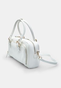 Sac à main en synthétique blanc avec deux compartiments zippés, accentué de quincaillerie dorée et de poignées doubles. Dispose d'une bandoulière amovible.