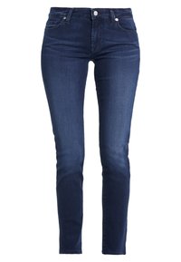 Jeans de mezclilla azul oscuro con corte ajustado, que presentan una cintura de altura media, un diseño tradicional de cinco bolsillos y un cierre frontal con botón.