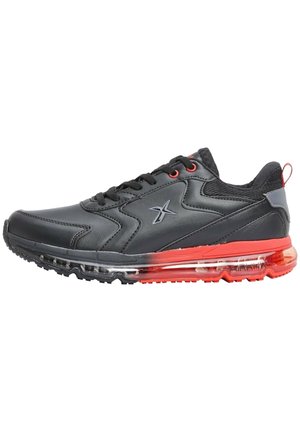 Baskets de sport noires et rouges avec semelle à coussin d'air visible, fermeture à lacets et un logo sur le côté.