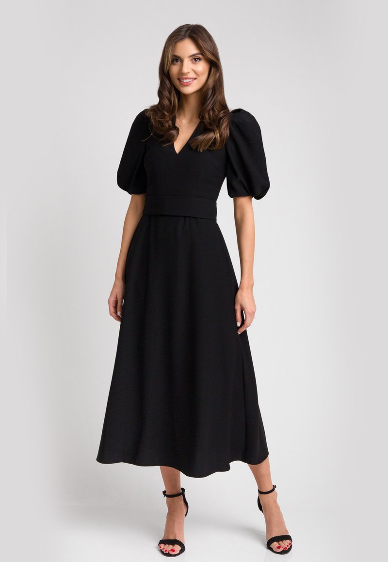 Czarna midi sukienka z krótkimi bufiastymi rękawami, głębokim dekoltem w serek, dopasowaną talią i luźną spódnicą. Gładki materiał z minimalnymi akcentami.