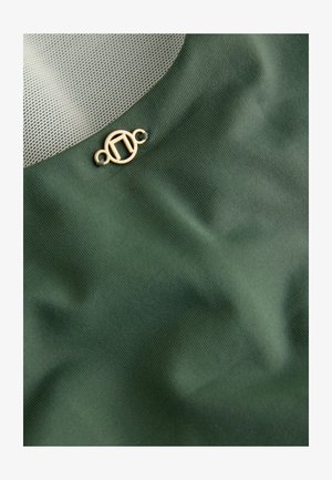 Olivengrøn stof med en glat overflade, der har et mesh-sektion og en lille guld cirkulær lukning detalje på den nederste side.