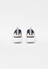 Navy and beige athletic shoes with mesh upper, suede accents, and a white rubber sole. Features a pull tab on the heel for easy wear.