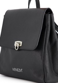 Sort læder håndtaske med en tekstureret overflade, en foldover klap og en sølv spænde. Har "VENEZIA" logoet på fronten.