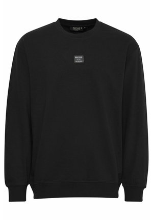 Musta huppari, joka on valmistettu pehmeästä materiaalista, jossa on pyöreä kaula-aukko, pitkät hihat ja pieni logo-merkki edessä. Ribbitetty hihansuu ja helma.