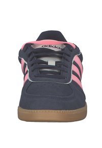 Granatowe zamszowe tenisówki z różowymi paskami, z okrągłym noskiem, sznurowane, z podeszwą z gumy naturalnej. Logo marki widoczne na języku.