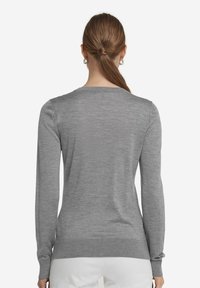 Grå långärmad tröja med rundad halsringning. Mjuk, texturerad stickad tyg. Ribbade ärmslut och nederkant. Klassisk passform, minimalistisk design.