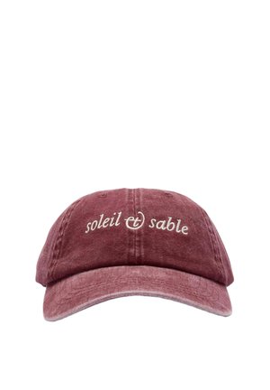 Abgenutzte gewaschene kastanienfarbene Baseballkappe mit weiß besticktem Text "soleil & sable" auf der Vorderseite in der Mitte.