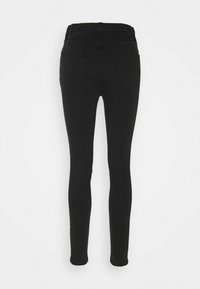 Jeans negros ajustados de cintura alta, con una textura de denim suave, cinco bolsillos y un diseño ceñido.
