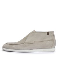 Zapatos slip-on de ante gris con un perfil bajo, que cuentan con una costura a lo largo de la parte superior y una suela de goma blanca. Acento de cuero marrón en el talón.