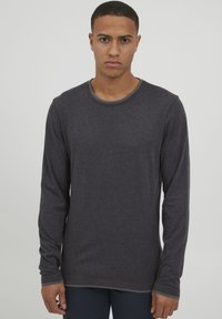 Donkergrijze longsleeve shirt gemaakt van zachte stof, met een ronde halslijn en een eenvoudig ontwerp zonder zichtbare patronen of hardware.
